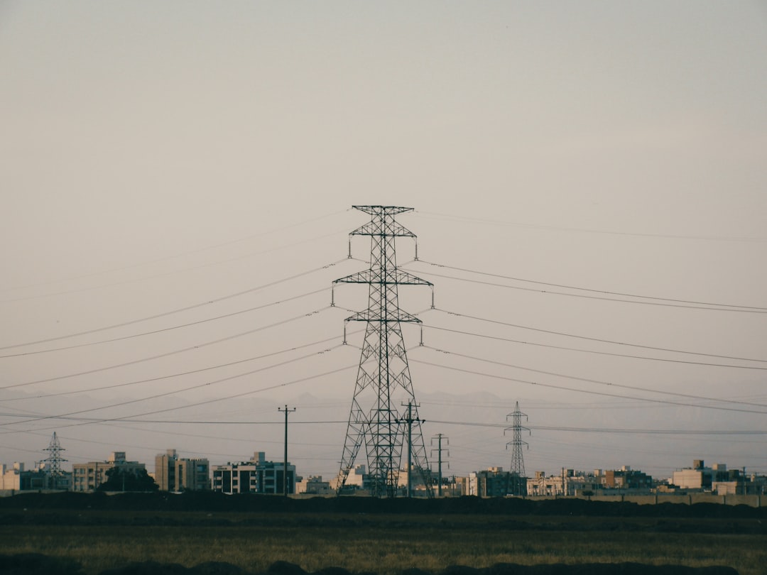 High-voltage lines near urban skyline at dusk